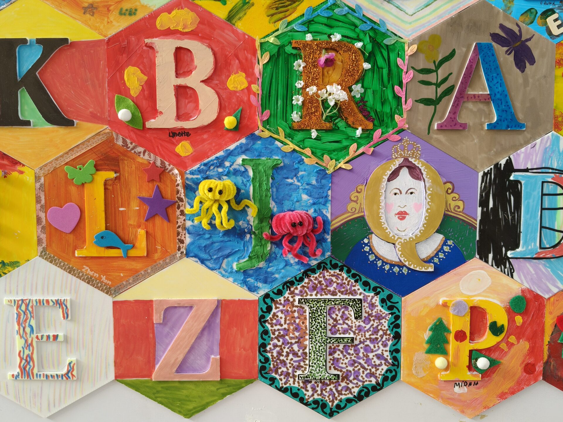 Close-up shot of 3D printed hexagonal alphabet tiles with artwork by SPD beneficiaries.
